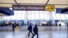 FILE - Sign points to a Transportation Security Administration (TSA) checkpoint at Dulles International Airport in Dulles, Va., March 26, 2019. 