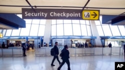 FILE - Sign points to a Transportation Security Administration (TSA) checkpoint at Dulles International Airport in Dulles, Va., March 26, 2019. 