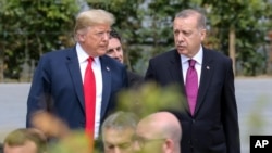 FILE - President Trump, speaks with Turkey's President Recep Tayyip Erdogan ahead of the opening ceremony of the NATO summit in Brussels, July 11, 2018.