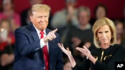FILE - Republican presidential candidate former President Donald Trump and moderator Laura Ingraham gesture on stage during a Fox News Channel town hall Feb. 20, 2024, in Greenville, SC.