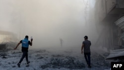 People and a journalist rush toward the scene of an explosion following an Israeli strike which reportedly targeted a school in the Zeitoun district on the outskirts of Gaza City, on Sept. 1, 2024.