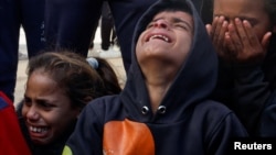 Children cry as people mourn Palestinians killed in an Israeli strike, at Nasser hospital in Khan Younis in the southern Gaza Strip, Dec. 5, 2024. 