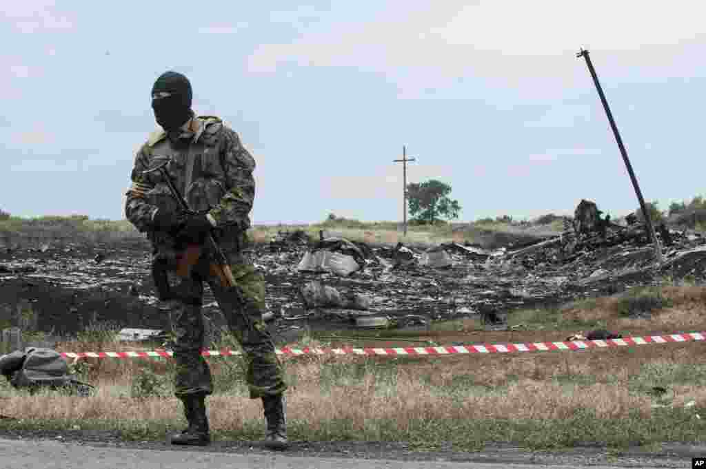 A pro-Russian fighter guards the crash site of a Malaysia Airlines jet near the village of Hrabove, eastern Ukraine, July 19, 2014.