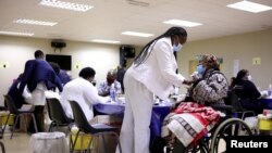 A woman receives a dose of a coronavirus disease (COVID-19) vaccine, as South Africa rolls out the coronavirus disease (COVID-19) vaccination to the elderly at the Munsieville Care for the Aged Centre outside Johannesburg, South Africa May 17, 2021.