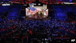 Delegates watch a video presentation during an abbreviated session of the Republican National Convention in Tampa, Florida, on Monday, Aug. 27, 2012.