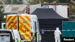 Police are seen at the scene where bodies were discovered in a truck container, in Grays, Essex, Britain, Oct. 23, 2019.