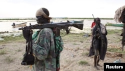 A Turkana man holds a rifle on the western shore of Lake Turkana in northern Kenya, Sept. 25, 2014. The Turkana people have historically clashed over ethnic differences and precious resources.