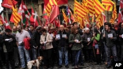 Pro-independence demonstrators of Catalonia and Basque Country raise their regional flags as they gather on a square to support an informal independence poll to celebrate in Catalonia, in Pamplona northern Spain, Nov. 9, 2014.