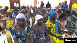 FILE - A still image taken from video shows freed captives of Boko Haram jihadists, sitting in a hall as they are welcomed by officials in Abuja, Nigeria, May 7, 2017. The girls were kidnapped in 2014 in Chibok.