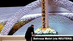 Perdana Menteri Jepang Yoshihide Suga meletakkan bunga di depan altar untuk para korban gempa bumi dan tsunami pada upacara peringatan 10 tahun bencana tersebut, di Tokyo, Jepang 11 Maret 2021. (Foto: Behrouz Mehri via Reuters)