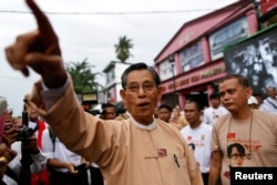 FILE - Tin Oo, co-founder of the National League for Democracy party, points out other party members at a ceremony to mark the 25th anniversary of the founding of the NLD, in Yangon, Myanmar, on Sept. 27, 2013.
