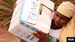 A woman helps load relief supplies onto a truck bound for northern Mali, April 13, 2012. 