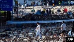 Pedestrians walk among bricks and debris left by protesters near the Hong Kong Polytechnic University in Hung Hom, Hong Kong, Nov. 16, 2019. 