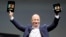 Amazon CEO Jeff Bezos holds up the new Kindle Fire HD 7" and Kindle Fire HD 8.9" (L) during Amazon's Kindle Fire event in Santa Monica, California Sep. 6, 2012. 