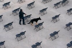 A law enforcement official sweeps a spectator seating area as preparations take place for President-elect Joe Biden's inauguration ceremony at the U.S. Capitol in Washington, Jan. 16, 2021.