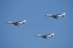 FILE - H-6K aircraft fly in formation during a commemoration of the 70th anniversary of Japan's surrender during World War II, in Beijing, Sept. 3, 2015.