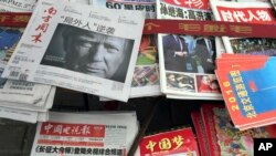 FILE - A front page of a Chinese newspaper with a photo of U.S. President-elect Donald Trump and the headline "Outsider counter attack" is displayed at a newsstand in Beijing, China, Nov. 10, 2016. 