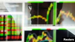 A trader works on the floor of the New York Stock Exchange shortly after market opens on Dec. 19, 2013. 