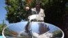 The photo is of SunFire's solar energy expert, Zander van Manen, cooking on a parabolic solar dish, Johannesburg, South Africa. (Darren Taylor/VOA)