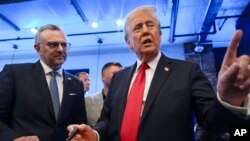 FILE - Republican presidential nominee former President Donald Trump signs autographs as Massad Boulos listens during an event in Dearborn, Michigan, Nov. 1, 2024.