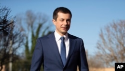 FILE - Democratic presidential candidate and former South Bend, Ind. Mayor Pete Buttigieg walks to speaks with members of the media, March 1, 2020, in Plains, Ga.