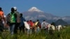 Central American migrants begin their morning trek as part of a thousands-strong caravan hoping to reach the U.S. border, as they face the Pico de Orizaba volcano upon departure from Cordoba, Veracruz state, Mexico, Monday, Nov. 5, 2018.