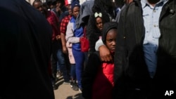 FILE - Migrants from Haiti stand in line outside the Mexican Commission for Refugee Aid government office to apply for asylum in Mexico City, Jan. 28, 2025.