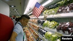FILE - A man stands at a fruit section of a supermarket in Hanoi, Vietnam, Sept. 20, 2014. 