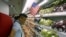 FILE - A man stands at a fruit section of a supermarket in Hanoi, Vietnam, Sept. 20, 2014. 