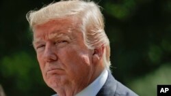 President Donald Trump looks toward members of his staff during a White House news conference in Washington, July 25, 2017.