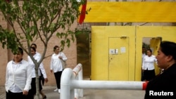 FILE - Ethnic Uighur women leave a center where political education lessons are held in Kashgar, in Xinjiang Uighur Autonomous Region, China, Sept. 6, 2018.