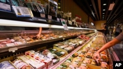 A customer shops at a supermarket for sushi and sashimi, some of which are labeled as from Japan, in Hong Kong, on Aug. 24, 2023.