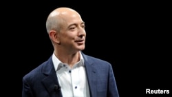 FILE - Amazon CEO Jeff Bezos demonstrates the Kindle Paperwhite during Amazon's Kindle Fire event in Santa Monica, California, Sept. 6, 2012.