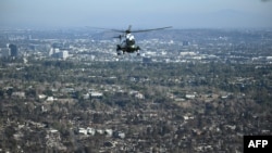 The Marine One helicopter, carrying U.S. President Donald Trump, flies above devastation caused by wildfires, near Los Angeles, California, Jan. 24, 2025. (Photo by Mandel Ngan/Pool/AFP)