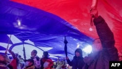 Supporters hoist a giant Taiwan national flag during a campaign rally of Kuomintang ahead of Taiwan's presidential election, in Taipei on Dec. 23, 2023.