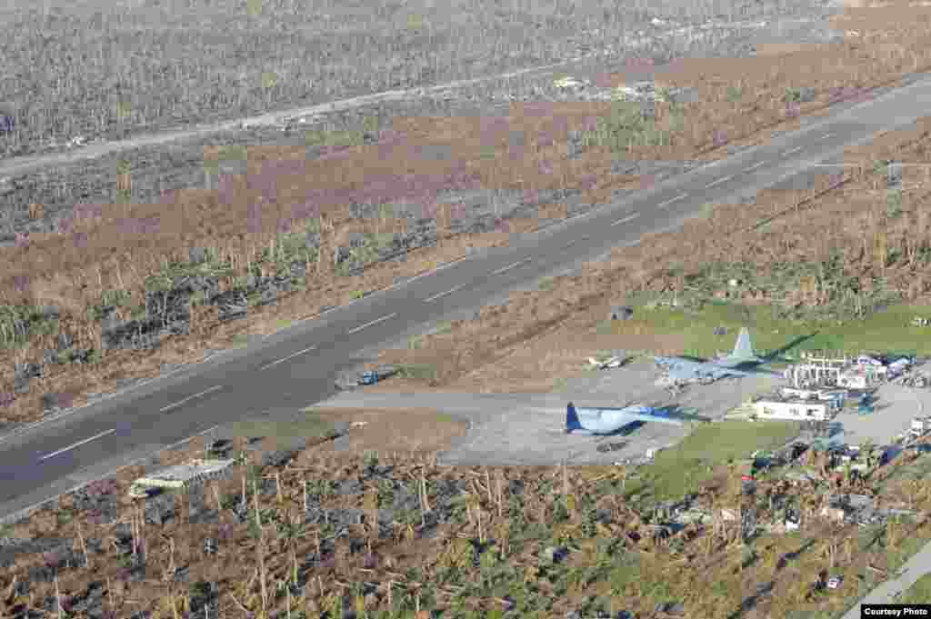 An HC-130 Hercules and other military aircraft sit on the tarmac at Guiuan airport waiting to airlift Philippine citizens in support of Operation Damayan. (U.S. Navy)
