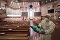 A worker disinfects pews at the Yoido Full Gospel Church in Seoul, South Korea, Aug. 21, 2020.