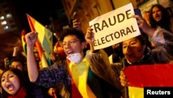 A protestor holds a banner reading "Electoral Fraud" as she takes part in a march in La Paz, Bolivia, Oct. 25, 2019. 