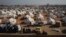 Internally displaced people walk among the tents in a camp in Tabqa city, Raqqa governorate, northern Syria, Dec. 4, 2024.