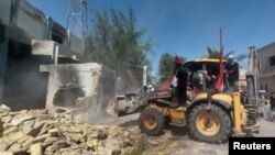Protesters use a bulldozer to demolish offices of Shiite parties during ongoing anti-government protests in Nasiriyah, Iraq, Aug. 22, 2020. 