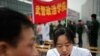 A member of the Chinese military forces gives a free medical check to a man as community service during the "Learning from Lei Feng Day" in a central square in Shanghai, March 5, 2012.