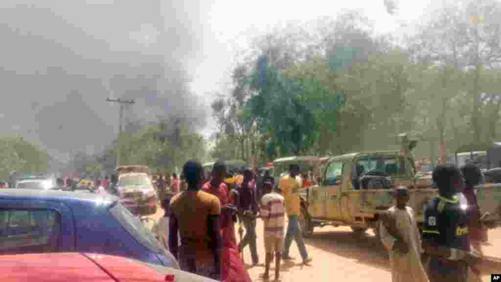 Mutane sunyi dafifi kewaye da inda boma-boman ya tashi a Maiduguri a ranar 14 ga watan Maris 2014.