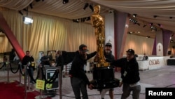 ภาพคนงานช่วยกันจัดวางรูปปั้นรางวัลออสการ์ ในพื้นที่จัดงานประกาศรางวัลประจำปีที่ยิ่งใหญ่ที่สุดของวงการภาพยนตร์ ในฮอลลีวู้ด ลอสแอนเจลิส เมื่อ 28 ก.พ. 2568