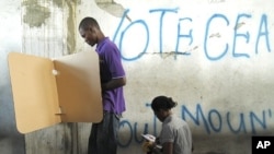 People mark their ballots during presidential elections in Port-au-Prince, March 21, 2011