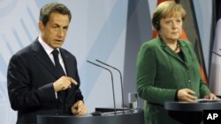 German chancellor Angela Merkel, right, and French President Nicolas Sarkozy talk to the media after a meeting on the financial crisis in Berlin, Germany, Sunday, Oct. 9, 2011.