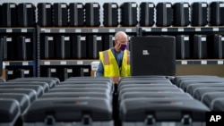 FILE - A worker prepares tabulators for the upcoming election, in Raleigh, North Carolina, Sept. 3, 2020. Early in-person voting starts Oct. 15, 2020, in all 100 counties in the battleground state.