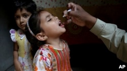 FILE - A health worker gives polio vaccine to a girl in Lahore, Pakistan, April 9, 2018. 