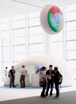 FILE - Attendees talk under a logo of Google's Chrome browser at the Google IO Developers Conference in San Francisco, May 11, 2011.