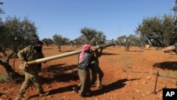 Rebel fighters prepare to fire a missile towards Syrian government positions in the province of Idlib, Feb. 9, 2020.