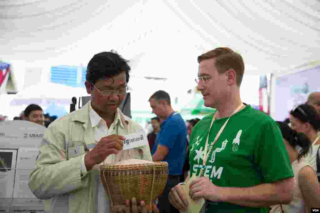 អនុប្រធាន​បេសកកម្ម​ស្ថានទូត​សហរដ្ឋ​អាមេរិក​ប្រចាំ​កម្ពុជា​និយាយ​ជាមួយ​សាស្រ្តាចារ្យ​ផលិត​អង្ករ​ម្នាក់​នៅ​ក្នុង​មហោស្រពជាតិ​ស្តី​ពីវិទ្យាសាស្រ្ត​និង​​វិស្វកម្ម​លើកទី​៥​ឆ្នាំ​២០១៩​ កាលពី​ថ្ងៃទី​២១ ខែកុម្ភៈ ឆ្នាំ២០១៩​ នៅ​ពហុកីឡាដ្ឋាន​អូឡាំពិក​ រាជធានី​ភ្នំពេញ​ ប្រទេស​កម្ពុជា។ (ទុំ ម្លិះ/VOA)